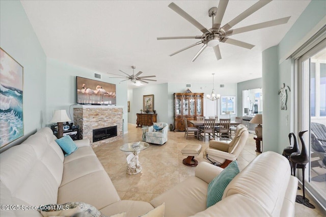 601 N Miramar Ave Unit 314, Indialantic, FL 32903 - living room featuring a ceiling fan, a stone fireplace, tile patterned flooring, and a chandelier