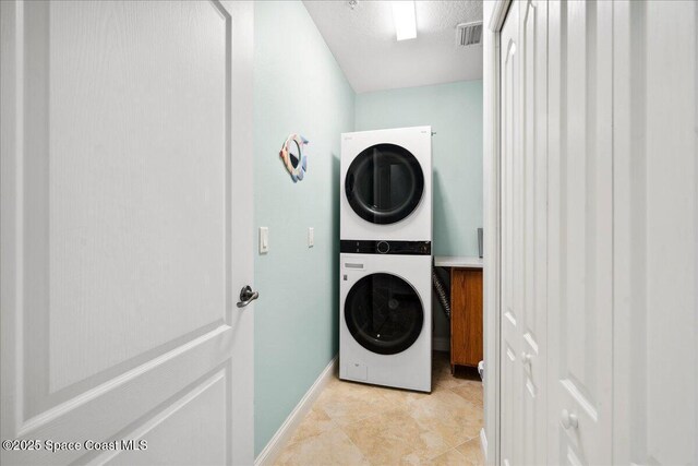 601 N Miramar Ave Unit 314, Indialantic, FL 32903 - washroom featuring stacked washing machine and dryer and baseboards