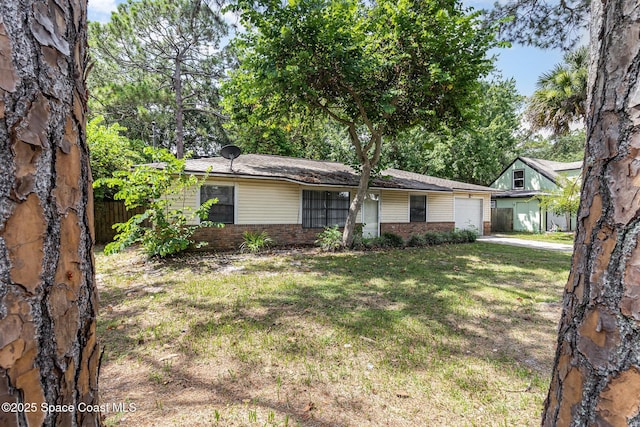 7413 Ester Rd, Cocoa, FL 32927 - view of front of property with brick siding, a garage, a front yard, and driveway