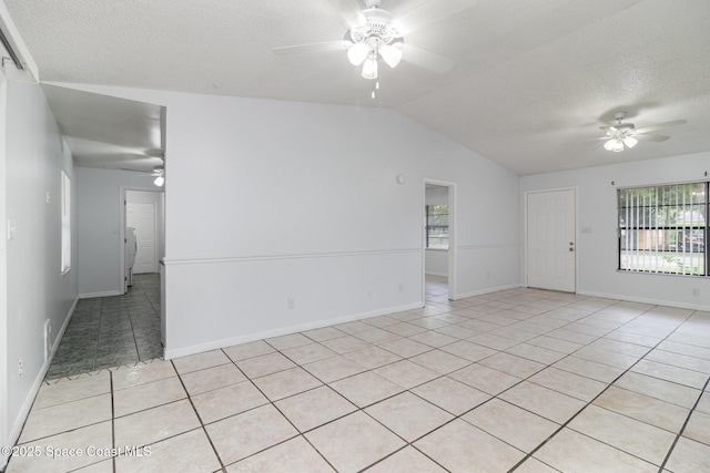 7413 Ester Rd, Cocoa, FL 32927 - spare room featuring ceiling fan, light tile patterned floors, vaulted ceiling, and a textured ceiling