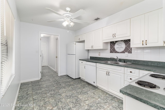 7413 Ester Rd, Cocoa, FL 32927 - kitchen with white appliances, dark countertops, white cabinets, and a ceiling fan