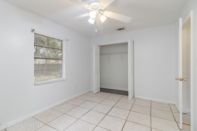 7413 Ester Rd, Cocoa, FL 32927 - unfurnished bedroom with light tile patterned flooring, a ceiling fan, a closet, and a textured ceiling