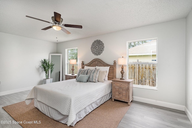 542 White Plains Ave SW, Palm Bay, FL 32908 - bedroom with light wood-style floors, baseboards, a textured ceiling, and ceiling fan