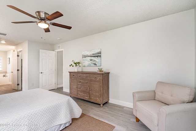 542 White Plains Ave SW, Palm Bay, FL 32908 - bedroom featuring wood finished floors, baseboards, a textured ceiling, ceiling fan, and ensuite bathroom