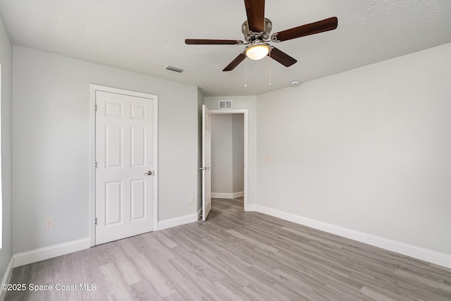 542 White Plains Ave SW, Palm Bay, FL 32908 - unfurnished bedroom with light wood-style floors, a textured ceiling, baseboards, and a ceiling fan