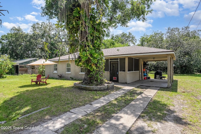 209 Plumosa Dr, Cocoa, FL 32922 - view of front of property with driveway, a front lawn, an attached carport, and concrete block siding