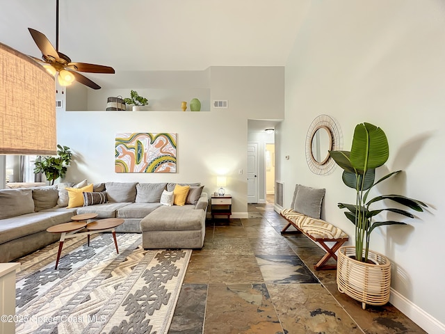 10360 Crystal Point Dr, Orlando, FL 32825 - living area featuring stone tile floors, baseboards, a ceiling fan, and a towering ceiling