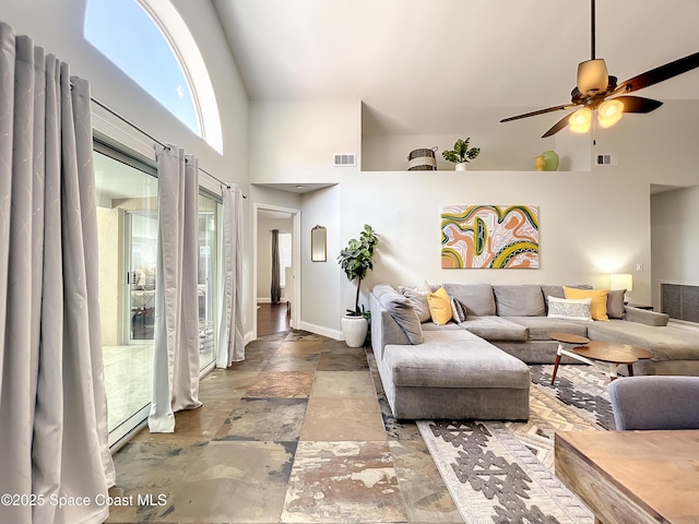 10360 Crystal Point Dr, Orlando, FL 32825 - living area featuring a high ceiling, stone tile flooring, ceiling fan, and baseboards