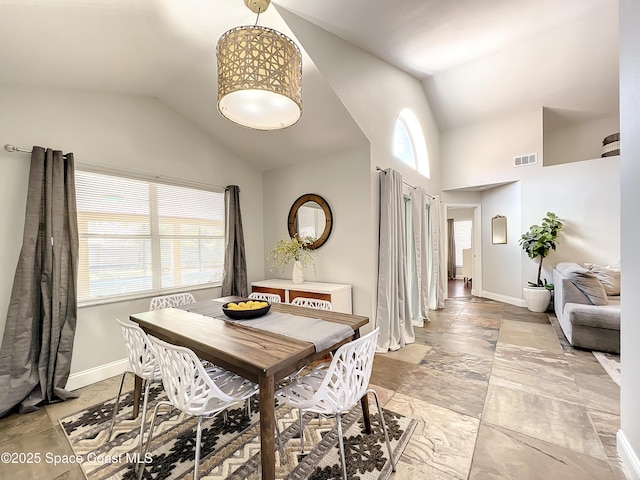 10360 Crystal Point Dr, Orlando, FL 32825 - dining space with baseboards, light stone finish floors, and high vaulted ceiling
