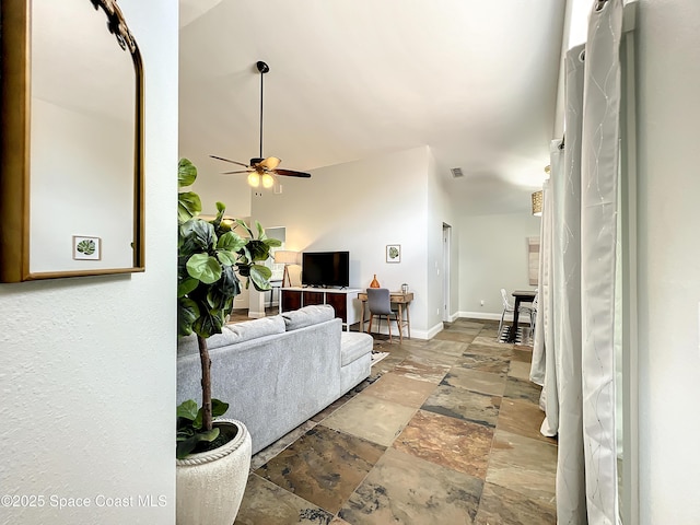 10360 Crystal Point Dr, Orlando, FL 32825 - living area featuring stone tile floors, ceiling fan, and baseboards