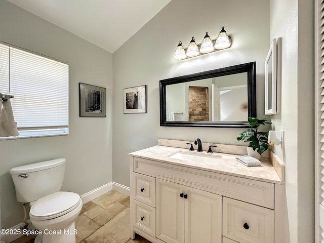 10360 Crystal Point Dr, Orlando, FL 32825 - bathroom with vaulted ceiling, vanity, baseboards, toilet, and stone tile flooring