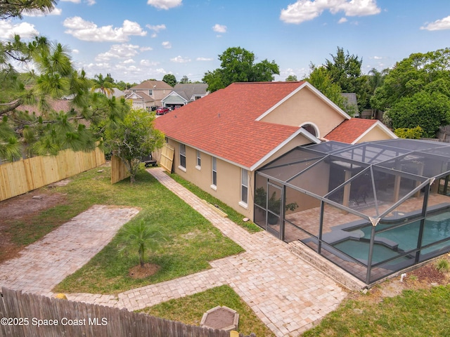 10360 Crystal Point Dr, Orlando, FL 32825 - rear view of house featuring stucco siding, a patio, a pool with connected hot tub, and glass enclosure