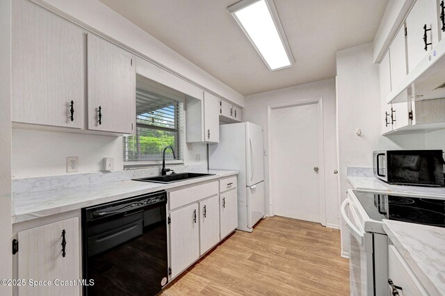 1123 Hermosa Dr, Rockledge, FL 32955 - kitchen with black appliances, a sink, light wood-style floors, light stone counters, and range hood