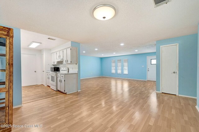 1123 Hermosa Dr, Rockledge, FL 32955 - kitchen with white range with electric stovetop, light wood-type flooring, a textured ceiling, light countertops, and baseboards