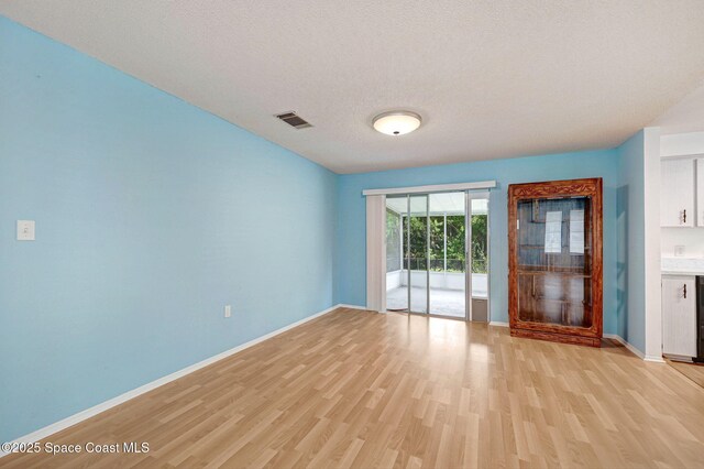 1123 Hermosa Dr, Rockledge, FL 32955 - spare room featuring light wood-type flooring, baseboards, and a textured ceiling