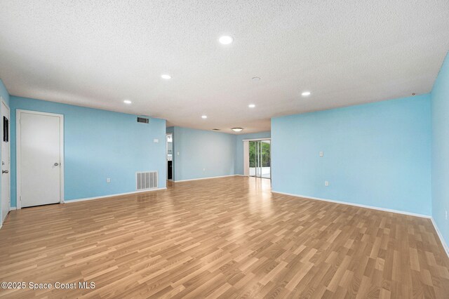 1123 Hermosa Dr, Rockledge, FL 32955 - empty room featuring a textured ceiling, light wood-style flooring, recessed lighting, and baseboards