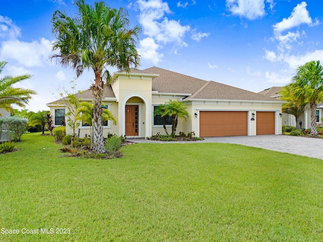 7406 Millbrook Ave, Melbourne, FL 32940 - mediterranean / spanish home featuring a garage, stucco siding, decorative driveway, a front lawn, and roof with shingles
