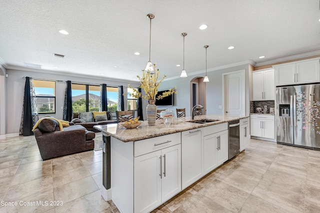 7406 Millbrook Ave, Melbourne, FL 32940 - kitchen featuring appliances with stainless steel finishes, crown molding, a center island with sink, recessed lighting, and tasteful backsplash