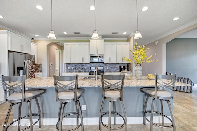 7406 Millbrook Ave, Melbourne, FL 32940 - kitchen with appliances with stainless steel finishes, arched walkways, tasteful backsplash, crown molding, and a spacious island