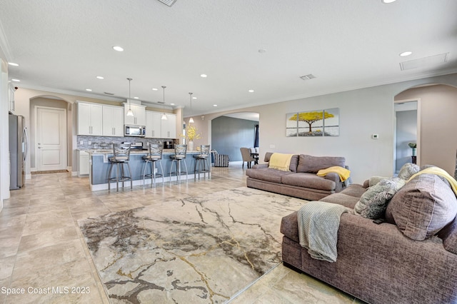 7406 Millbrook Ave, Melbourne, FL 32940 - living room featuring recessed lighting, crown molding, and arched walkways