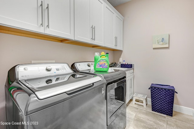 7406 Millbrook Ave, Melbourne, FL 32940 - laundry area featuring washer and dryer, cabinet space, and light tile patterned floors