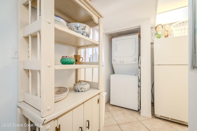 3060 N Atlantic Ave Unit 602, Cocoa Beach, FL 32931 - laundry area featuring stacked washer and clothes dryer and light tile patterned floors
