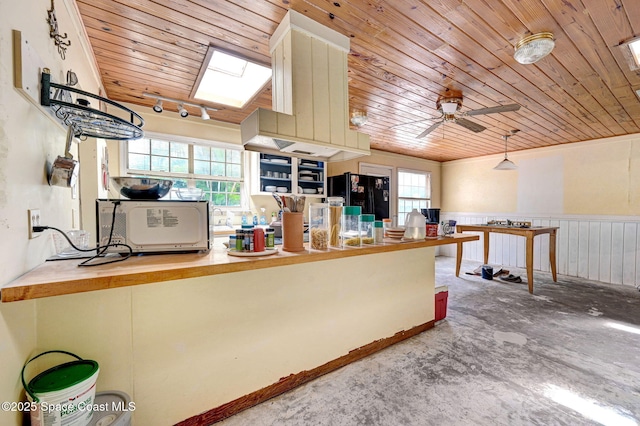 409 Stendal Rd NW, Palm Bay, FL 32907 - kitchen featuring black fridge with ice dispenser, wood ceiling, ceiling fan, wooden counters, and wainscoting