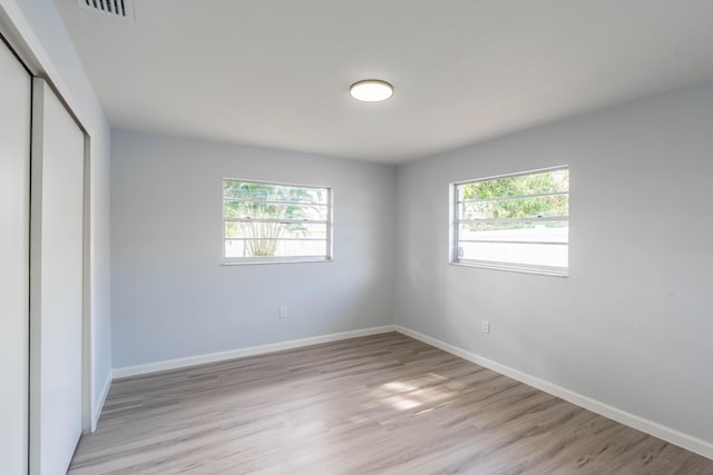 306 Harvey Ave NE, Palm Bay, FL 32907 - unfurnished bedroom featuring a closet, baseboards, and light wood-type flooring