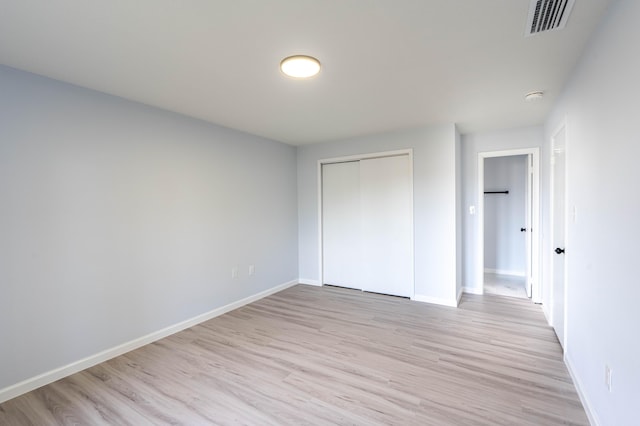 306 Harvey Ave NE, Palm Bay, FL 32907 - unfurnished bedroom featuring light wood-style flooring, a closet, and baseboards