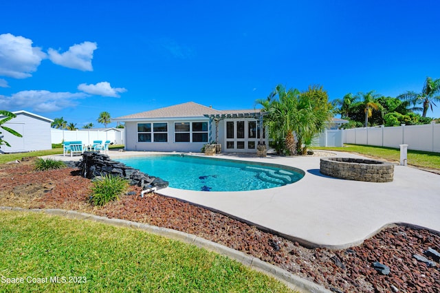 1455 Centaurus Ct, Merritt Island, FL 32953 - view of pool with a fire pit, a patio area, an outbuilding, a fenced backyard, and french doors