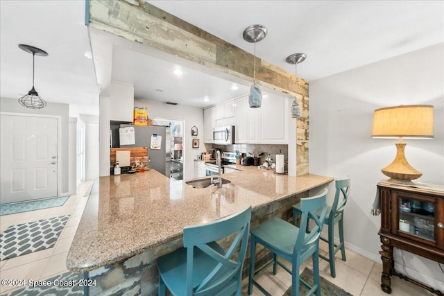 190 Shell Pl Unit 84, Rockledge, FL 32955 - kitchen with light tile patterned floors, appliances with stainless steel finishes, white cabinetry, a peninsula, and recessed lighting