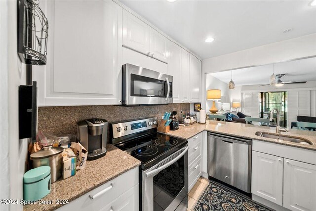190 Shell Pl Unit 84, Rockledge, FL 32955 - kitchen featuring stainless steel appliances, a sink, decorative backsplash, white cabinets, and recessed lighting