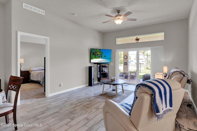 4070 Sage Brush Cir, Melbourne, FL 32901 - living area with light wood-type flooring, ceiling fan, and a textured ceiling