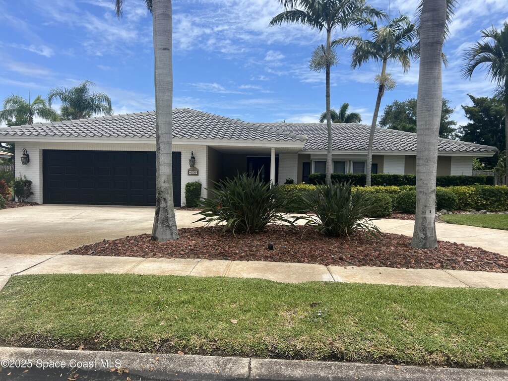 630 Seville Ct, Satellite Beach, FL 32937 - single story home featuring a tile roof, an attached garage, and driveway