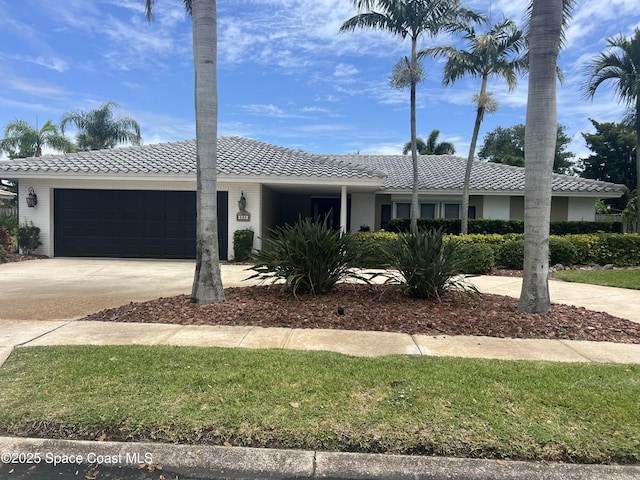 630 Seville Ct, Satellite Beach, FL 32937 - single story home featuring a tile roof, an attached garage, and driveway