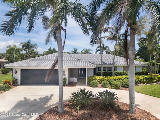 630 Seville Ct, Satellite Beach, FL 32937 - ranch-style house with a tile roof, concrete driveway, a garage, and stucco siding