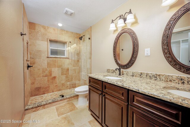 630 Seville Ct, Satellite Beach, FL 32937 - full bathroom featuring double vanity, a tile shower, and stone finish flooring