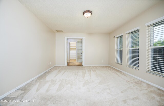 630 Seville Ct, Satellite Beach, FL 32937 - empty room featuring light colored carpet and a textured ceiling