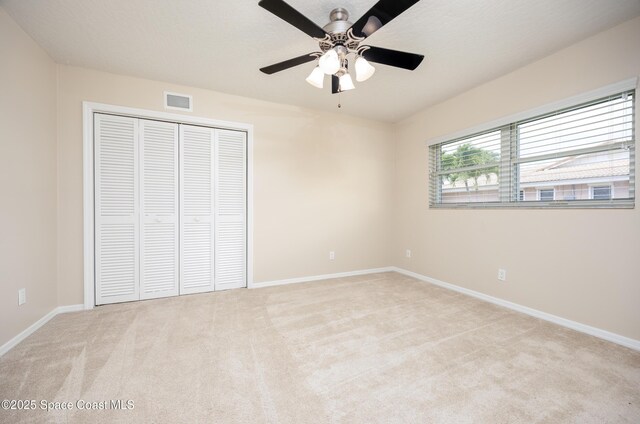 630 Seville Ct, Satellite Beach, FL 32937 - unfurnished bedroom with light carpet, a closet, and a ceiling fan
