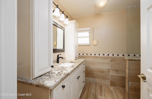 630 Seville Ct, Satellite Beach, FL 32937 - bathroom featuring vanity, tile walls, and wood finished floors