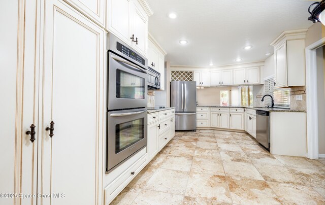 630 Seville Ct, Satellite Beach, FL 32937 - kitchen featuring stainless steel appliances, stone counters, decorative backsplash, recessed lighting, and white cabinets