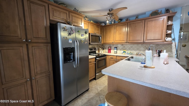 8714 Jasmine Ct, Cape Canaveral, FL 32920 - kitchen with appliances with stainless steel finishes, a sink, light countertops, decorative backsplash, and brown cabinets