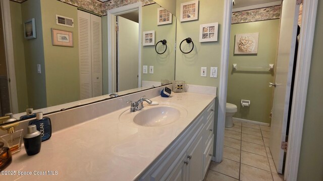 8714 Jasmine Ct, Cape Canaveral, FL 32920 - bathroom featuring toilet, vanity, tile patterned flooring, and a closet