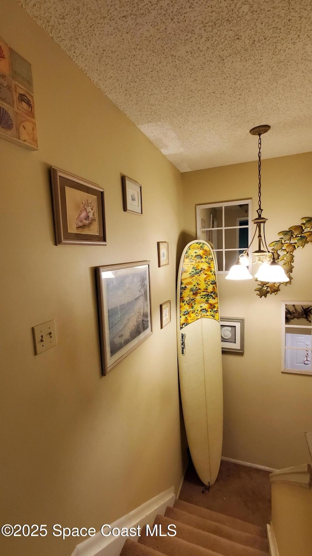 8714 Jasmine Ct, Cape Canaveral, FL 32920 - corridor featuring baseboards, a textured ceiling, and carpet