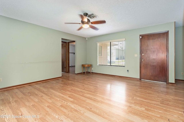 662 Estaugh St NW, Palm Bay, FL 32907 - unfurnished room with a ceiling fan, light wood-style floors, baseboards, and a textured ceiling