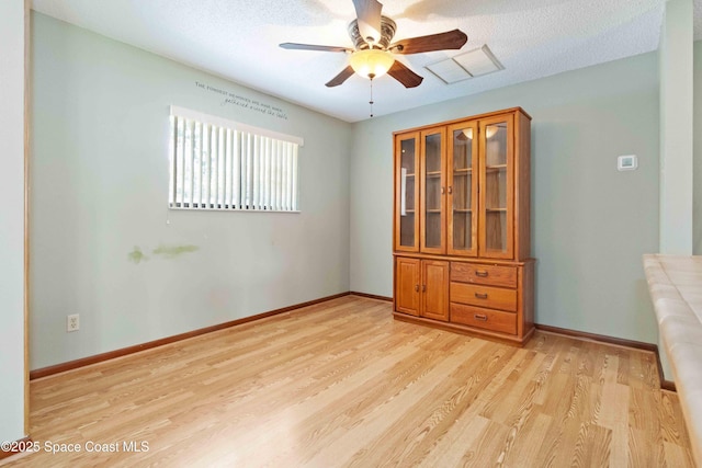 662 Estaugh St NW, Palm Bay, FL 32907 - spare room with ceiling fan, light wood-type flooring, baseboards, and a textured ceiling