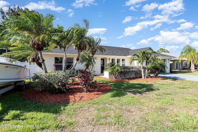 670 S Oak Park Cir E, Merritt Island, FL 32953 - ranch-style house with a front lawn and stucco siding