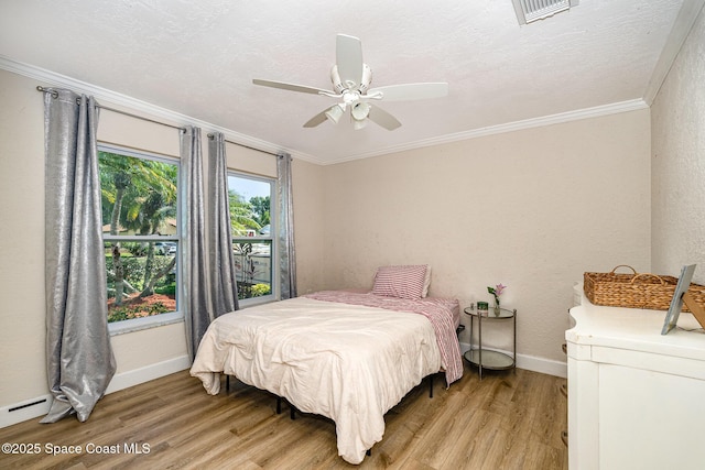 670 S Oak Park Cir E, Merritt Island, FL 32953 - bedroom featuring light wood-type flooring, crown molding, ceiling fan, and a baseboard heating unit
