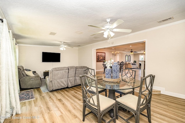 670 S Oak Park Cir E, Merritt Island, FL 32953 - dining room featuring a ceiling fan, light wood-style flooring, ornamental molding, a textured ceiling, and a chandelier