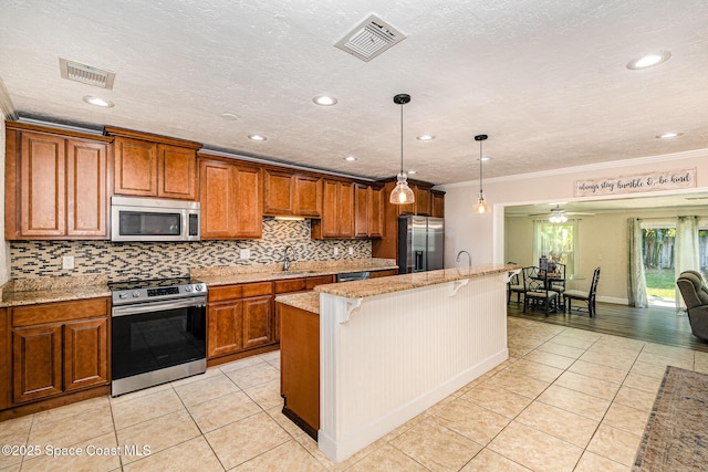 670 S Oak Park Cir E, Merritt Island, FL 32953 - kitchen featuring stainless steel appliances, light tile patterned floors, brown cabinets, a kitchen bar, and crown molding